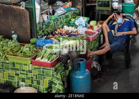 Manila, Philippinen. Januar 2021. Ein Verkäufer, der eine Maske trägt, macht ein Nickerchen auf einem Markt in Manila, Philippinen, 5. Januar 2021. Die Inflation auf den Philippinen stieg im Vergleich zum Vorjahr im Dezember 2020 auf 3.5 Prozent, ein Anstieg von 3.3 Prozent im November 2020, getrieben von einem Anstieg der Nahrungsmittel und alkoholfreien Getränke, teilte die Philippine Statistics Authority (PSA) am Dienstag mit. PSA-Chef Dennis Mapa sagte einer virtuellen Pressekonferenz, dass dies die höchste Inflation seit März 2019 sei. Quelle: Rouelle Umali/Xinhua/Alamy Live News Stockfoto