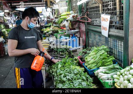 Manila, Philippinen. Januar 2021. Ein Verkäufer trägt eine Maske befeuchtet Gemüse, das auf einem Markt in Manila, Philippinen, 5. Januar 2021 verkauft wird. Die Inflation auf den Philippinen stieg im Vergleich zum Vorjahr im Dezember 2020 auf 3.5 Prozent, ein Anstieg von 3.3 Prozent im November 2020, getrieben von einem Anstieg der Nahrungsmittel und alkoholfreien Getränke, teilte die Philippine Statistics Authority (PSA) am Dienstag mit. PSA-Chef Dennis Mapa sagte einer virtuellen Pressekonferenz, dass dies die höchste Inflation seit März 2019 sei. Quelle: Rouelle Umali/Xinhua/Alamy Live News Stockfoto