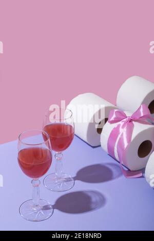 Paar Gläser mit Wein und Toilettenpapier als Geschenk in einem rosa Band. Platz für Text Stockfoto
