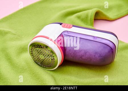 Stoffrasierer auf dem grünen Pullover. Nahaufnahme, selektiver Fokus Stockfoto