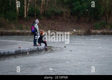 Glasgow, Schottland, Großbritannien. Januar 2021. Im Bild: Skater auf dem Teicheis. Queens Park in Shawlands, der heute Morgen nur wenige Menschen im Park und auf dem Eis zeigt, bildet einen deutlichen Kontrast zu den Szenen von gestern, in denen Hunderte von Menschen auf dem Eis, Schlittschuhlaufen, Hockey spielen und um den Park herum zu sehen waren. Ab 00:01 Uhr heute Morgen wurde Schottland erneut gesperrt, wie es die Ansprache des schottischen Ersten Ministers gestern um 14:00 Uhr erklärte. Quelle: Colin Fisher/Alamy Live News. Stockfoto