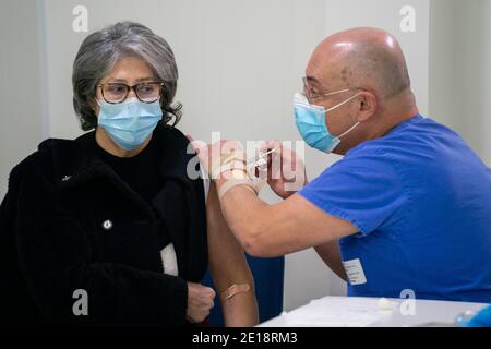 Krankenschwester, die einen Mann mit dem Impfstoff Pfizer-BioNTech Covid 19 impft Stockfoto