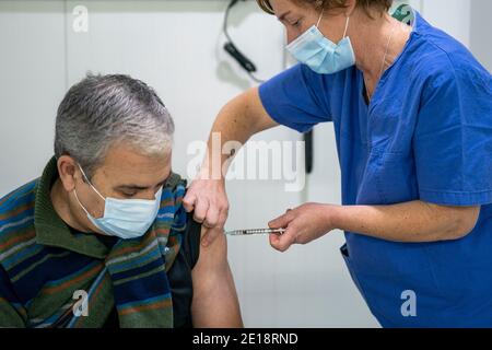 Krankenschwester, die einen Mann mit dem Impfstoff Pfizer-BioNTech Covid 19 impft Stockfoto