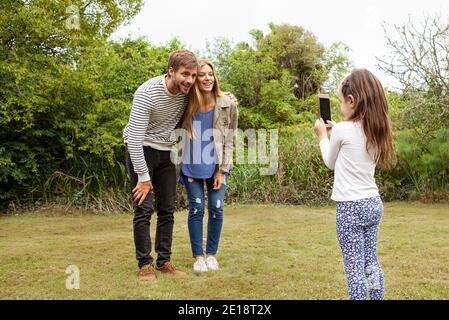 Mädchen fotografieren ihre Eltern im Garten Stockfoto