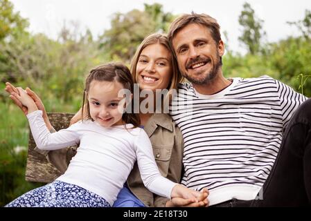 Porträt einer glücklichen Familie auf der Bank sitzen Stockfoto