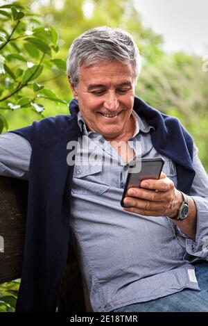 Lächelnder älterer Mann am Telefon Stockfoto