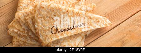 Nahaufnahme eines Stapels gefalteter Crepes (französische Pfannkuchen) auf panoramischer Holzhintergrund, Wort Chandeleur Stockfoto