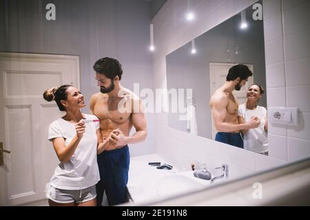 Glückliches junges Paar begeistert über positive Schwangerschaftstest Ergebnisse. Stockfoto