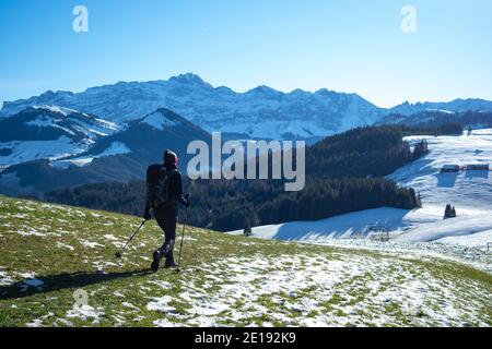 Ein Wanderer, der auf dem Neckertaler Höhenweg in Richtung Saentis, einem Schweizer Berg, geht Stockfoto