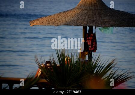 Sonnenschirm am Strand mit Utensilien zum Schwimmen Stockfoto