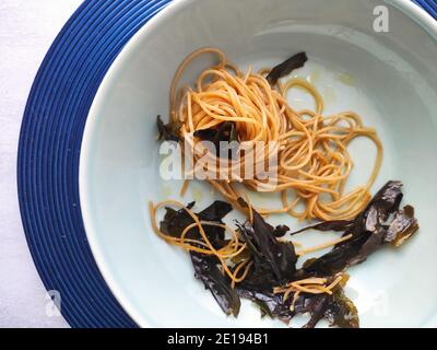 Kombu Seetang Spaghetti in einem blauen Teller Stockfoto