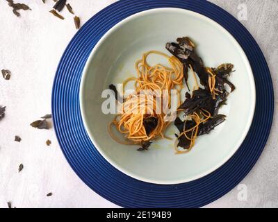 Kombu Seetang Spaghetti in einem blauen Teller Stockfoto