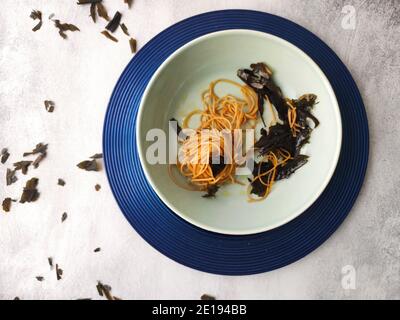 Kombu Seetang Spaghetti in einem blauen Teller Stockfoto