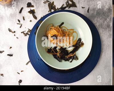 Kombu Seetang Spaghetti in einem blauen Teller Stockfoto