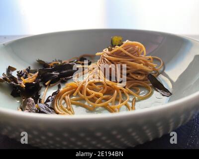 Kombu Seetang Spaghetti in einem blauen Teller Stockfoto