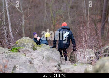 Halberstadt, Deutschland. Dezember 2020. Wanderer steigen in der Klusberge einen Hang hinunter. Die bizarren Felsformationen bei Halberstadt sehen aus wie das Elbsandsteingebirge in Miniatur. Mehrere Sandsteinfelsen enthalten Höhlenkammern, die erstmals 1070 in Dokumenten erwähnt wurden. Im 16. Jahrhundert war in den Klusbergen der Tradition nach eine "Bruderschaft der Hirten und Hirtenkinder" aktiv. Quelle: Stephan Schulz/dpa-Zentralbild/ZB/dpa/Alamy Live News Stockfoto