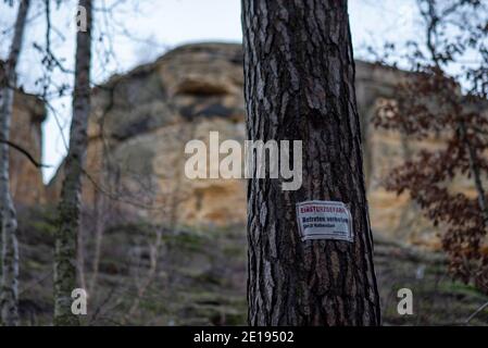 Halberstadt, Deutschland. Dezember 2020. In der Klusberge bei Halberstadt warnt ein Schild davor, an den Hängen entlang der Sandsteinfelsen zu wandern. Es besteht die Gefahr des Zusammenbruchs. Die Gebirgskette am Fuße des Harzes sieht aus wie das Elbsandsteingebirge in Miniatur. In mehreren Sandsteinfelsen befinden sich Höhlenräume, die erstmals im Jahr 1070 urkundlich erwähnt wurden. Im 16. Jahrhundert war in den Klusbergen der Tradition nach eine "Bruderschaft der Hirten und Hirtenkinder" aktiv. Quelle: Stephan Schulz/dpa-Zentralbild/ZB/dpa/Alamy Live News Stockfoto