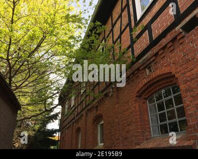 Schöne historische und alte rote Backstein Fachwerkscheune im Frühjahr Stockfoto