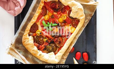 Hausgemachte Pizza mit frischen Tomaten und etwas Basilikum Stockfoto