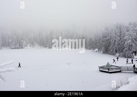 Winterlandschaft mit Kindern Spaß auf schneebedeckten, gefrorenen Mummelsee im Schwarzwald, Deutschland Stockfoto