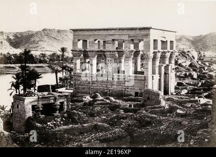 Vintage-Foto aus dem 19. Jahrhundert: Ansicht des Kiosks von Trajan auf der Insel Philae, Ägypten. Die Struktur, auch bekannt als "Pharaos Bett", wurde unter Kaiser Trajan (AD 53-117) errichtet. In den 1970er Jahren wurde der gesamte Komplex abgebaut und auf die nahe gelegene Insel Agilqiyya im Rahmen eines UNESCO-Projekts verlagert, um eine Reihe von antiken Denkmälern aus dem aufsteigenden Wasser des Nasser-Sees nach dem Bau des Assuan-Staudamms zu retten. Stockfoto