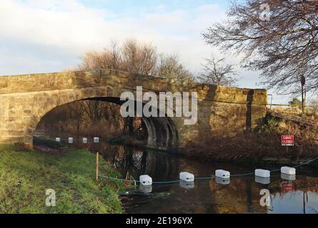 Die Whinnyfield Bridge, die Zufahrtssteinbrücke eines Bauern über den Lancaster-Kanal, wurde bei einem Fahrzeugstreik beschädigt, der Kanal ist für die Schifffahrt gesperrt. Stockfoto