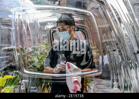 Manila. Januar 2021. Ein Mitarbeiter, der eine Gesichtsmaske trägt, reinigt am 5. Januar 2021 in einem Hotel in Manila, Philippinen, eine multifunktionale Blase. Das Hotel wird die multifunktionalen Luftpolsterfolie für Gäste öffnen, um sie vor COVID-19-Infektionen zu schützen. Quelle: Rouelle Umali/Xinhua/Alamy Live News Stockfoto