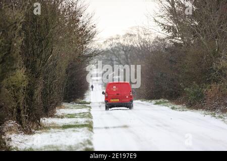 Barnard Castle, Teesdale, County Durham, Großbritannien. Januar 2021. Wetter in Großbritannien. Ein Postarbeiter der Royal Mail fährt heute Morgen auf einer schneebedeckten Straße am Stadtrand von Barnard Castle entlang, da schwere Schneeschauer Teile Nordenglands treffen. Kredit: David Forster/Alamy Live Nachrichten Stockfoto