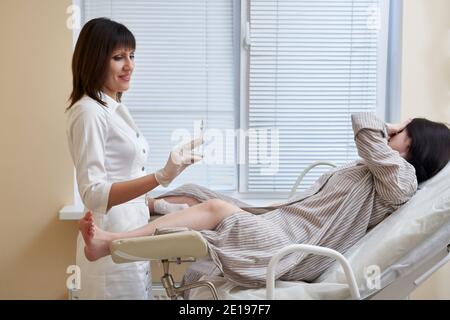 Frauenarzt mit Spritze macht eine Injektion zu Patienten in der Gynäkologie Stuhl Stockfoto