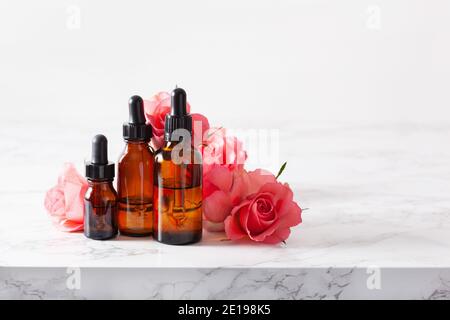 Ätherische Öle in Flaschen rosa Blüten. alternative Medizin Aromatherapie Stockfoto