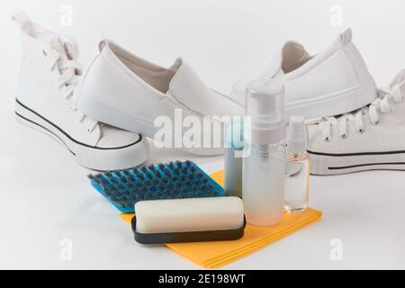 Reinigungsset und weiße Schuhe auf weißem Hintergrund Stockfoto