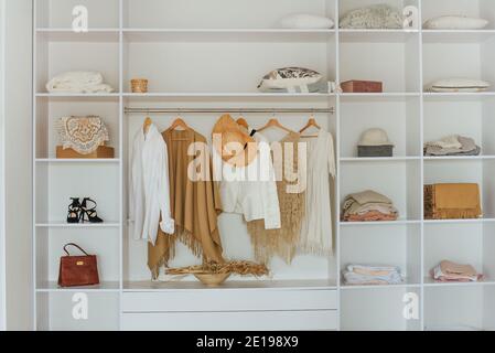 Offener weißer Einbauschrank mit weiblicher Kleidung Stockfoto
