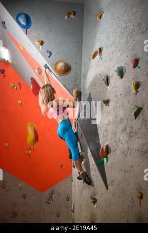 Kletterhalle. Junge Frau Kletterer Bouldering. Extreme Sport und Indoor Climbing Konzept Stockfoto