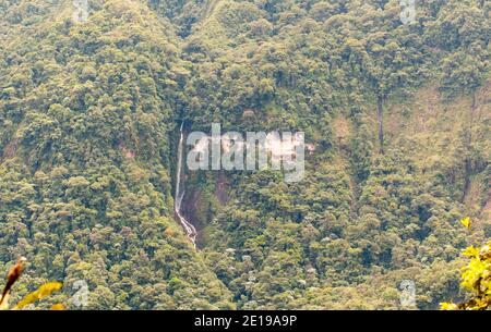 Steile Klippe mit Wasserfall und Kalksteinausbissen im Quijos-Tal, dem ecuadorianischen Amazonas. Der primäre Bergregenwald wächst auf der Klippe. Stockfoto