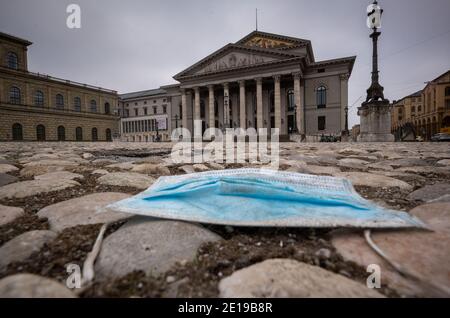 München, Deutschland. Januar 2021. Ein blauer Mundnasenschutz liegt auf dem Bürgersteig vor der Bayerischen Staatsoper im Zentrum der Stadt. Kredit: Peter Kneffel/dpa/Alamy Live Nachrichten Stockfoto