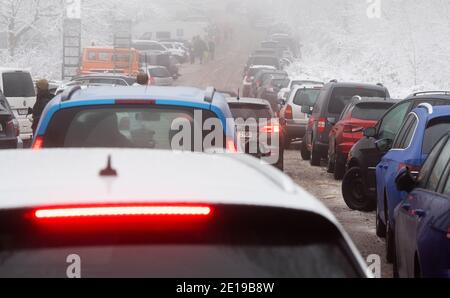 Nienstedt, Deutschland. Januar 2021. Autos fahren auf einen überfüllten Parkplatz am Nienstedter Pass im Deister. Polizei Hannover und Ordnungsamt melden überfüllte Parkplätze im verschneiten Deister. Kredit: Julian Stratenschulte/dpa/Alamy Live Nachrichten Stockfoto