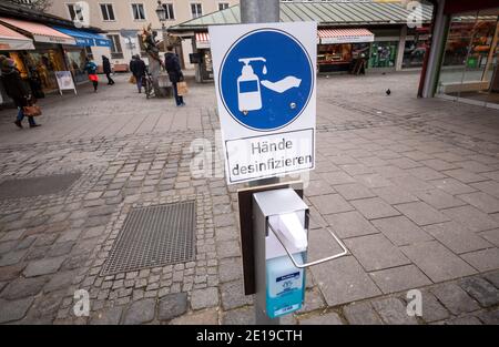 München, Deutschland. Januar 2021. Ein Schild mit der Aufschrift "Desinfect Hands" hängt über einem Desinfektionsmittelspender am Eingang zum Viktualienmarkt. Kredit: Peter Kneffel/dpa/Alamy Live Nachrichten Stockfoto