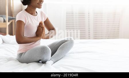 Kurze schwarze Frau im Schlafanzug Yoga zu Hause üben Stockfoto