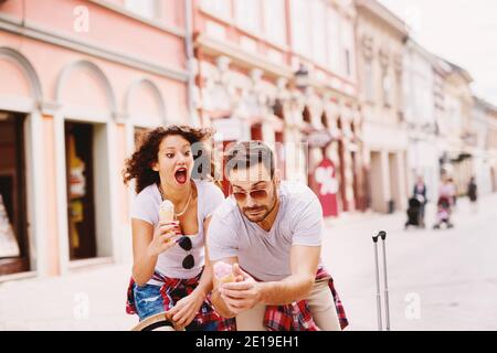 Moment, wenn junger Mann Eis fallen und schönes Mädchen neben ihm schreit. Stockfoto