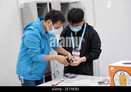 (210105) -- CHONGQING, 5. Januar 2021 (Xinhua) -- Liang Pan (R) arbeitet als Assistent des Schiedsrichters für Elektronik beim ersten nationalen Berufsbildungswettbewerb in Guangzhou, südchinesische Provinz Guangdong, 10. Dezember 2020. Liang Pan, der einst die Abitur nicht bestanden hatte, ist heute Lehrer am Chongqing Technician College of Railway Transportation. Von einem Berufsschüler, einem Laien in der Elektronik bis hin zu einem Experten und Weltmeister brauchte Liang Pan 6 Jahre, um sich den Traum zu erfüllen. Die Arbeitserfahrungen in sehr jungen Jahren haben Liang Pan das i realisiert Stockfoto