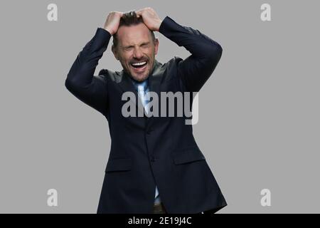 Verzweifelter Geschäftsmann, der seine Haare herauszieht. Stockfoto