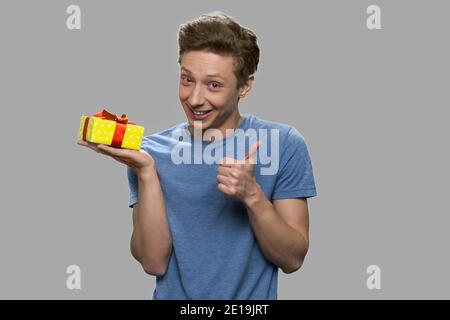 Lustige teen junge halten Geschenkbox. Stockfoto