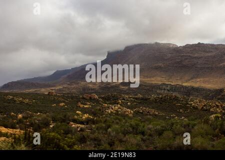 Die Cederberg-Berge, Südafrika, mit den Gipfeln, die von tief liegenden Wolken eines sich aufsammenden Sturms umhüllt sind Stockfoto