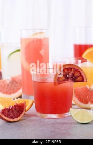 Erfrischender frisch gepresster sizilianischer Orangensaft unter frischen Detox-Zitrusfrüchten aus Orange, Grapefruit, Limette Stockfoto