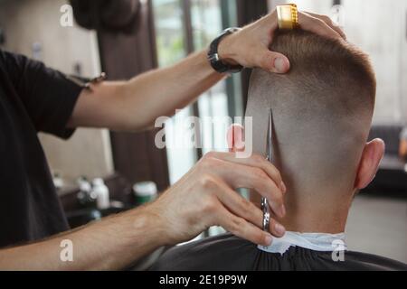 Nahaufnahme der Rückansicht eines Friseursalon mit einer Schere, Schneiden von Haaren des männlichen Kunden Stockfoto