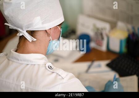 Junge Arzt arbeitet mit Patienten Papiere oder Dokumente. Arbeit des Ärzteteams in der Augenarztpraxis. Reife weibliche Arzt schreibt medizinische Formen. Stadt Stockfoto