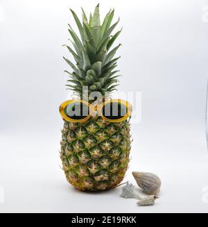 Mode Ananas mit Sonnenbrille auf weißem Hintergrund, Sommerferien, Urlaub und Food-Konzept Stockfoto