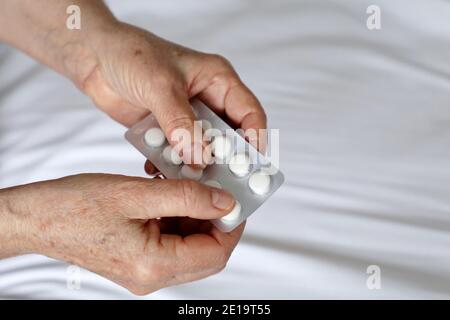 Ältere Frau mit Pillen in faltigen Händen. Konzept der Medikamente für Herz, Beruhigungsmittel Stockfoto