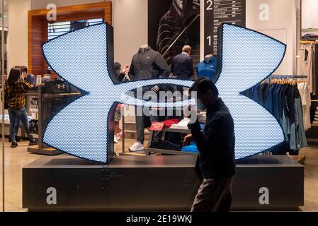 Ein Fußgänger geht an der amerikanischen multinationalen Bekleidungsmarke Under Armour vorbei, die in Hongkong zu sehen ist. Stockfoto