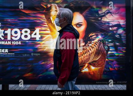 Hongkong, China. Dezember 2020. Ein Fußgänger geht an einer Werbetafel von Warner Bros Official Site und DC Comics Charakter Wonder Woman 1984 Film in Hong Kong vorbei. Kredit: Budrul Chukrut/SOPA Images/ZUMA Wire/Alamy Live Nachrichten Stockfoto